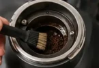 Breville Smart Grinder Pro burr area being cleaned with a dry brush